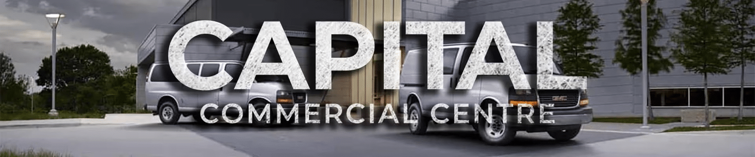 "Capital Commercial Centre text overlaying parked vans near a modern building at dusk."