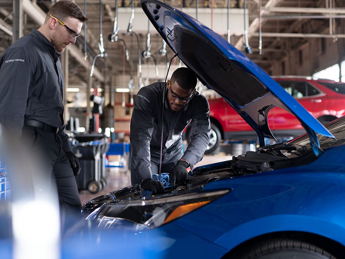 Mechanic adjusting a brake caliper on a car's brake system.