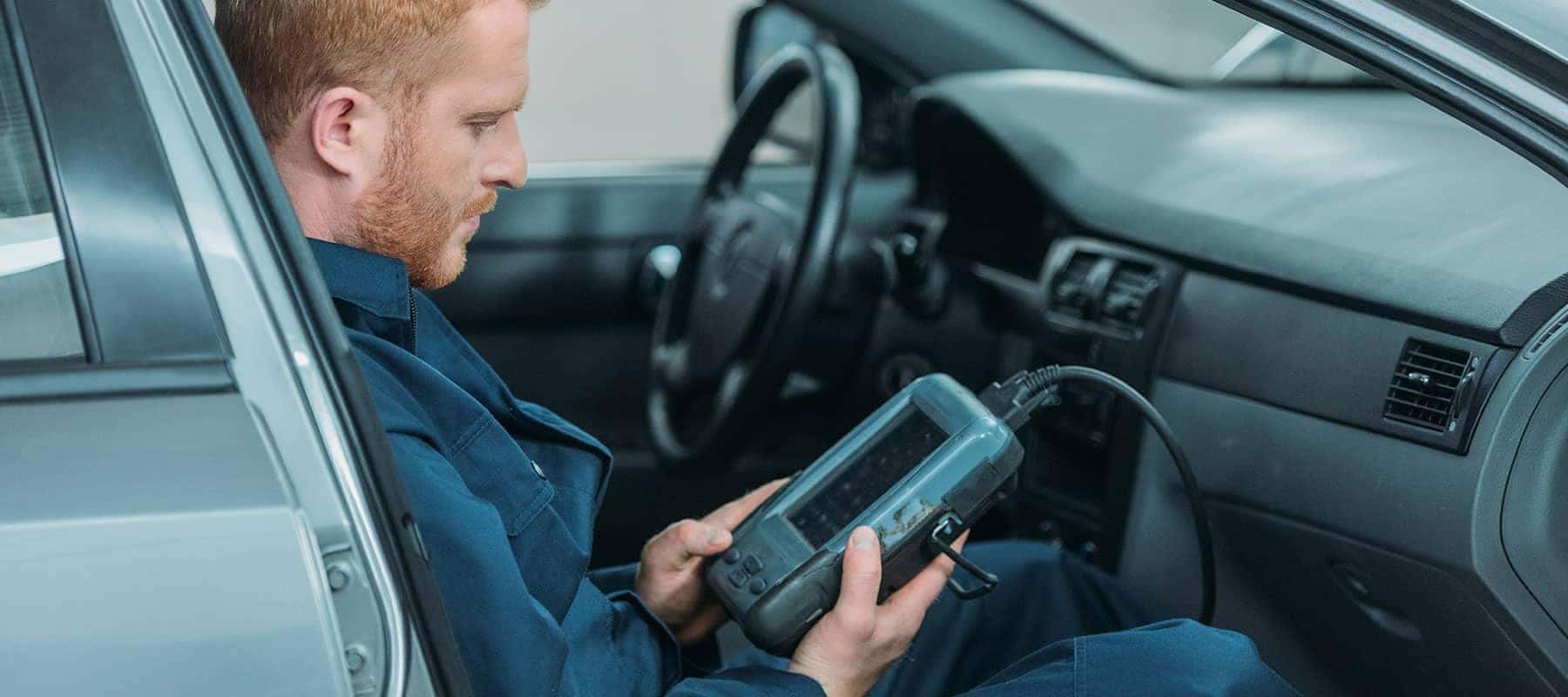 Hands using a multimeter for car diagnostics, measuring electronic components.