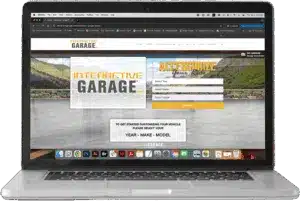 Laptop displaying the Interactive Garage website for vehicle customization, with options to select year, make, and model.
