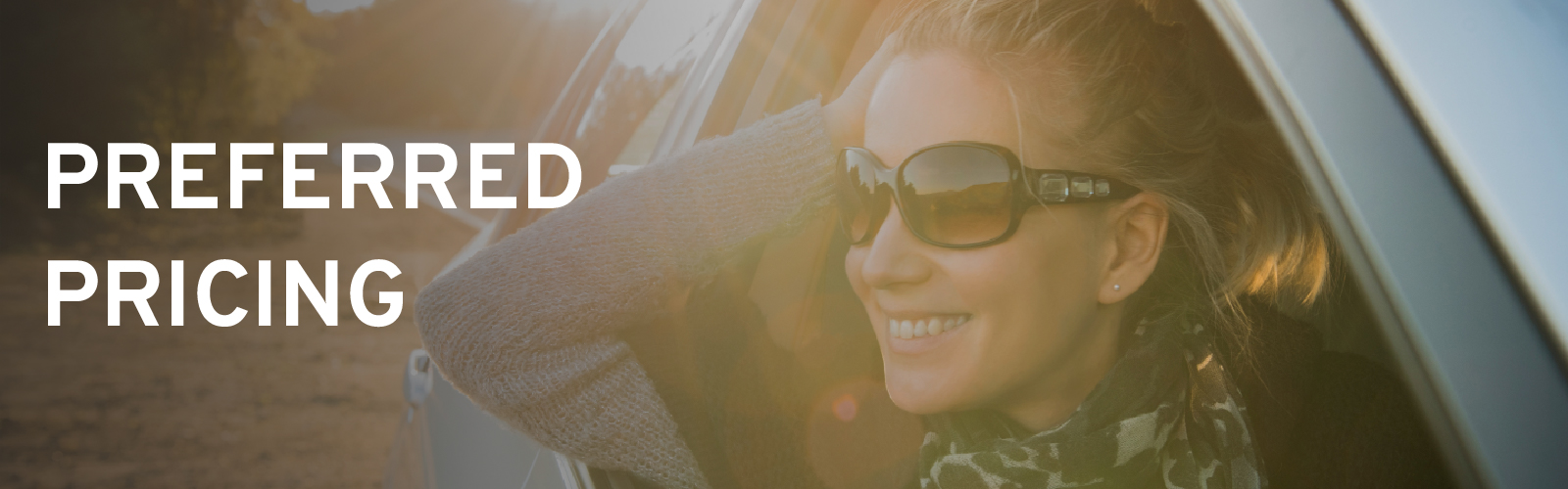 Smiling woman in sunglasses looks out car window, text "Preferred Pricing" on left side.