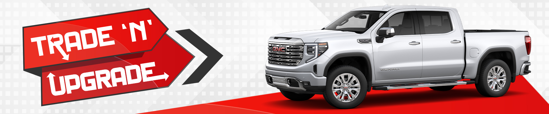 White GMC truck with "Trade 'N' Upgrade" text on a red arrow sign, promoting vehicle upgrade offers.